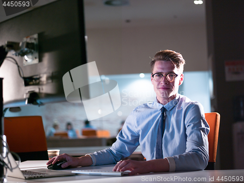 Image of man working on computer in dark office