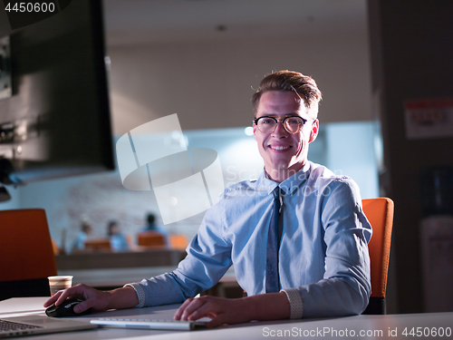 Image of man working on computer in dark office