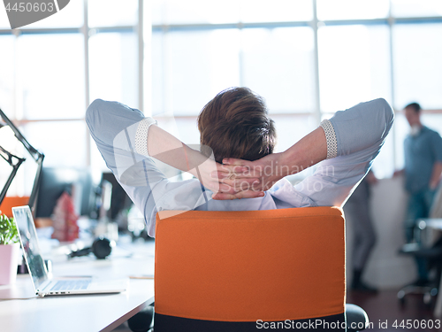 Image of young businessman relaxing at the desk