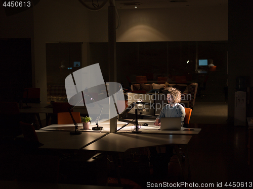 Image of man working on computer in dark office