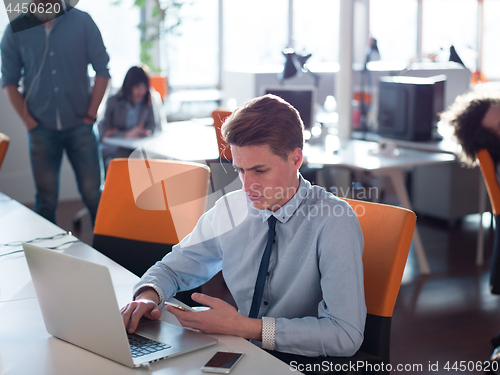 Image of businessman working using a laptop in startup office