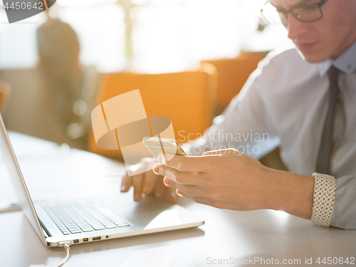 Image of Young man holding smartphone