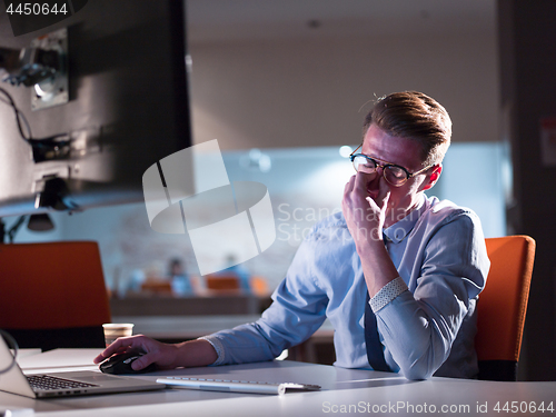 Image of man working on computer in dark office