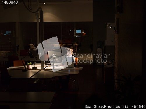 Image of man working on computer in dark office