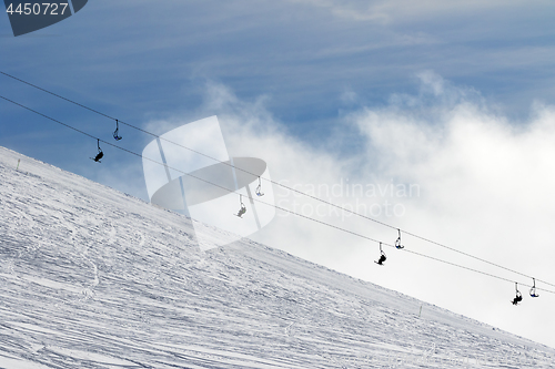 Image of Snow off-piste ski slope and chair-lift in fog