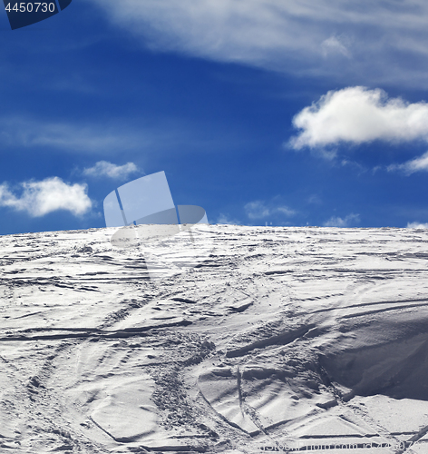 Image of Off-piste slope with track from ski and snowboard and blue sky w