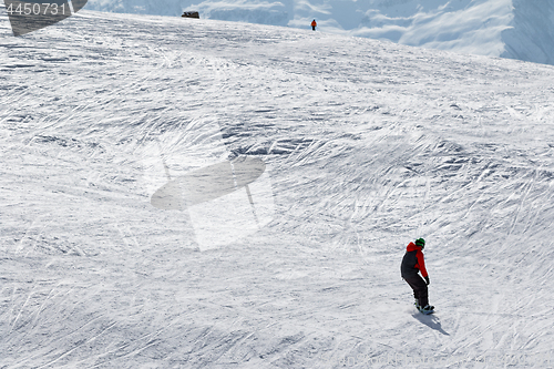 Image of Snowboarder and skier downhill on snow off-piste slope