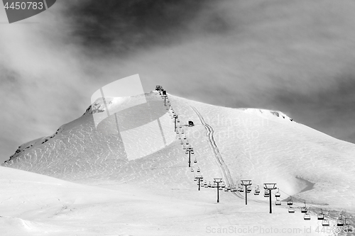 Image of Black and white view on ski slope and chair-lift at sun winter m