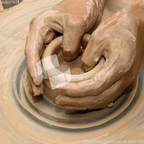 Image of Hands in clay at process of making ceramic on pottery wheel