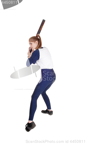 Image of Woman swinging her bat in softball