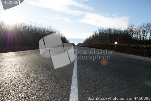 Image of asphalt road with markings and sunlight