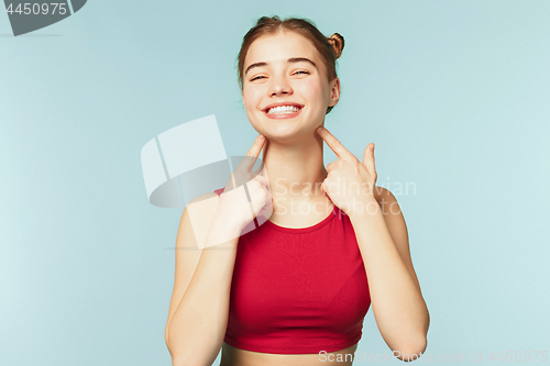 Image of Woman smiling with perfect smile on the blue studio background