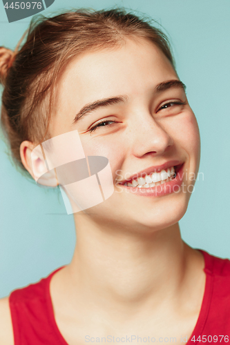 Image of Woman smiling with perfect smile on the blue studio background and looking at camera