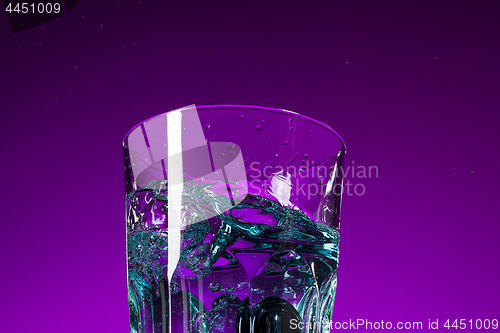 Image of The water splashing in glass on lilac background