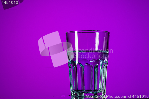 Image of The water in glass on lilac background