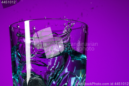 Image of The water splashing in glass on lilac background