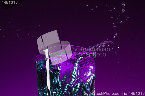 Image of The water splashing in glass on lilac background