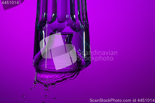 Image of The water splashing in glass on lilac background