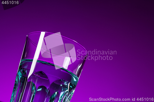 Image of The water in glass on lilac background