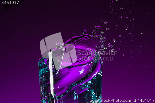 Image of The water splashing in glass on lilac background