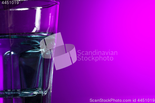 Image of The water in glass on lilac background