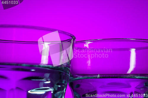 Image of The water in two glassese on lilac background