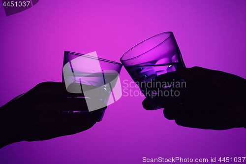 Image of Two wine glasses and male and female hands.