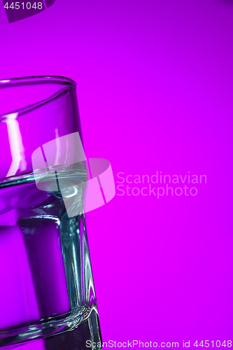 Image of The water in glass on lilac background