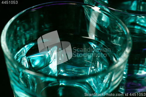 Image of The water in two glassese on lilac background