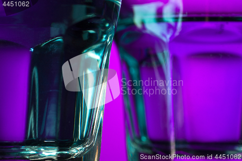 Image of The water in two glassese on lilac background