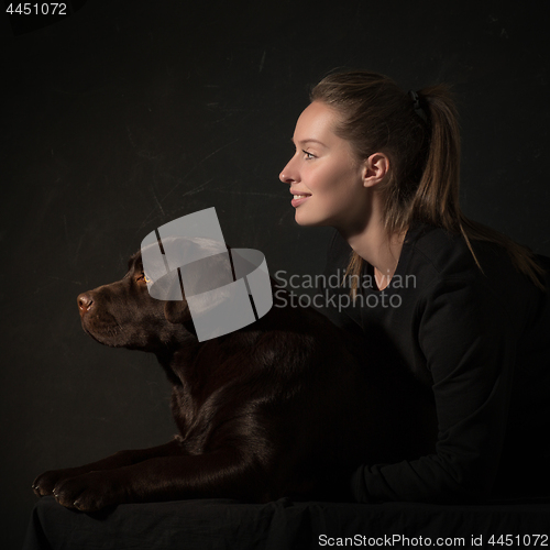 Image of The young woman hugging a mix breed dog