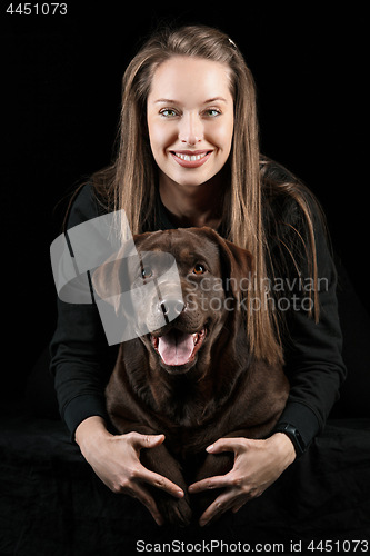Image of The young woman hugging a mix breed dog