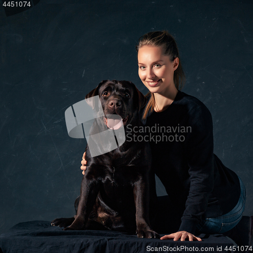 Image of The young woman hugging a mix breed dog