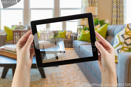 Image of Female Hands Holding Computer Tablet In Room with Photo on Scree