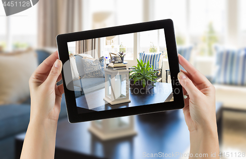 Image of Female Hands Holding Computer Tablet In Room with Photo on Scree