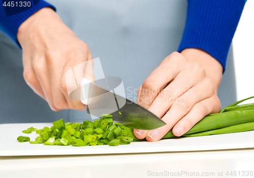 Image of Cook is chopping green onion