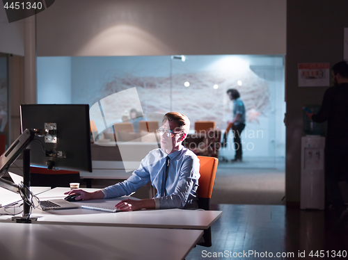 Image of man working on computer in dark office