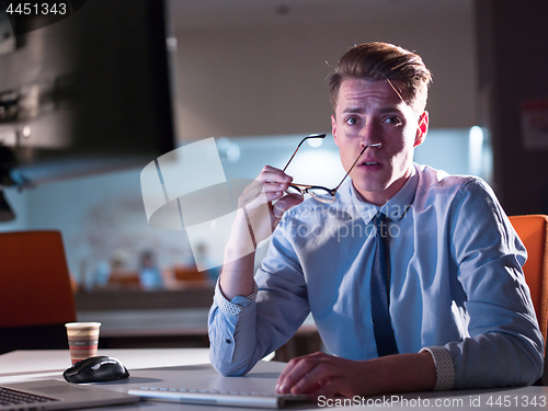 Image of man working on computer in dark office