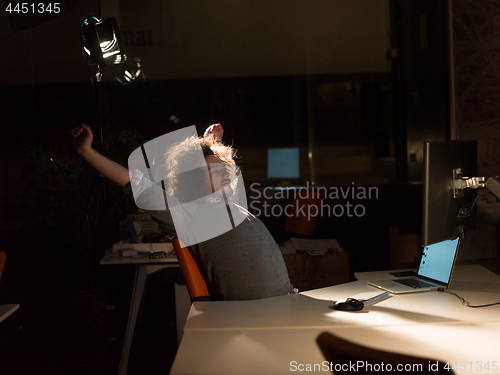 Image of man working on computer in dark office