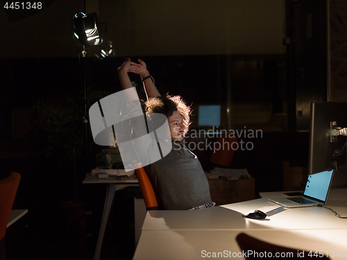 Image of man working on computer in dark office