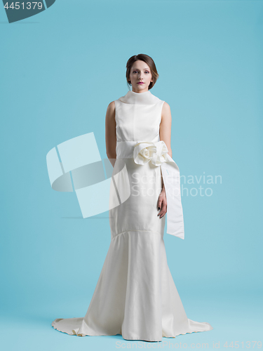 Image of beautiful woman wearing wedding dress against cyan background