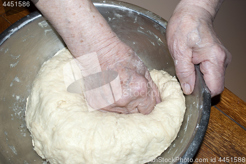 Image of elderly hands knead the dough