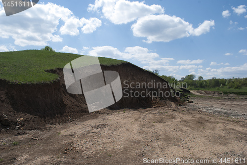 Image of earthen ravine on top of green grass