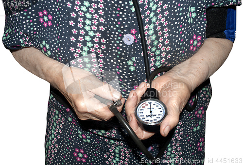 Image of an elderly woman measures her pressure with a tonometer