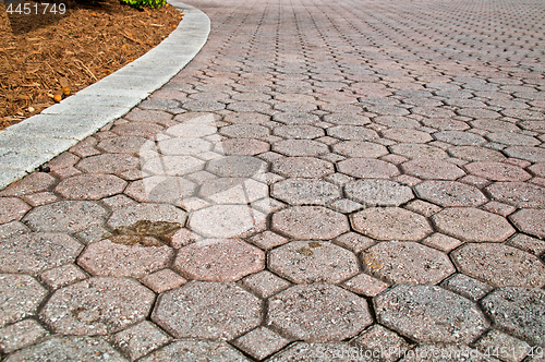 Image of low angle stained brick paver driveway
