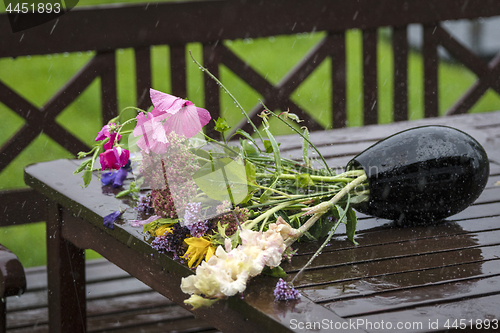 Image of Rain over a vase with a bouquet of colorful flowers