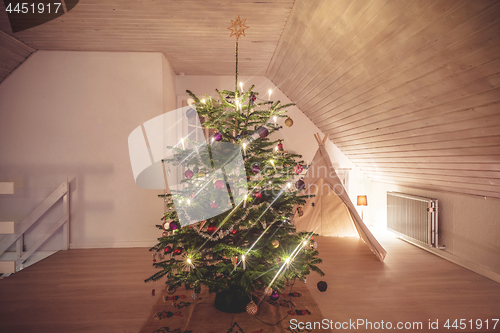 Image of Christmas tree with glittering lights in a living room in the ho