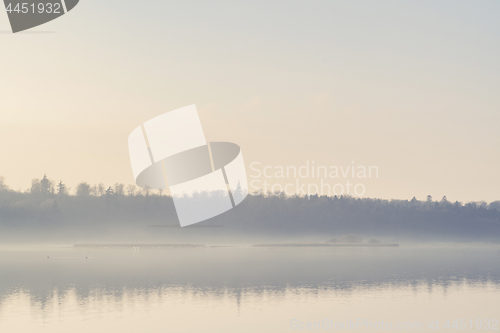 Image of Mist hanging over a quiet lake in the early morning