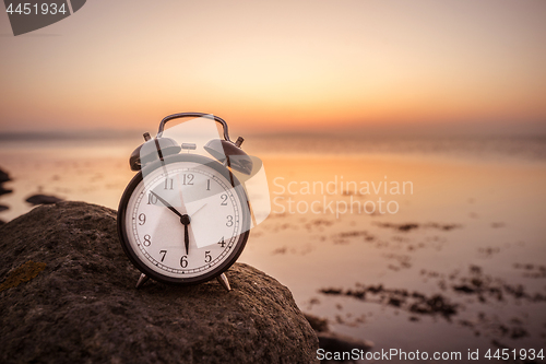 Image of Alarm clock early in the morning on a rock