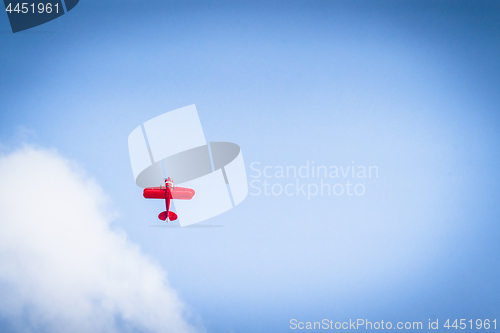 Image of Red propeller plane flying upwards